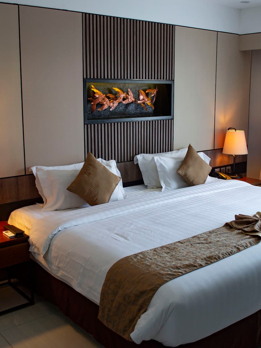 Executive suite bedroom with premium bedding and warm lighting